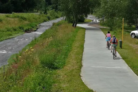 Rowerzyści cieszą się malowniczą trasą velo Krynica wzdłuż rzeki.