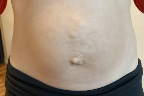 En mage med synliga delade magmuskler och navel.