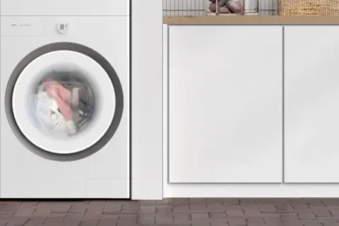 Lavatrice TCL in funzione, con panni colorati in movimento nel cestello. Il display indica 00:59, suggerendo quanto dura una lavatrice.