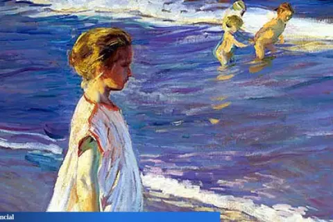 Niños en la playa, capturados con la luz vibrante de Sorolla. Una niña mira al mar mientras otros juegan en el agua.
