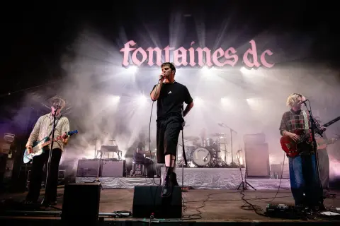 Fontaines D.C. live in Stuttgart, mit Sänger im Scheinwerferlicht und Band auf der Bühne.