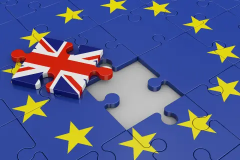 Fragment układanki z flagą Wielkiej Brytanii obok Unii Europejskiej. Symbolizuje Brexit, a w szerszym kontekście może nawiązywać do trudności w relacjach międzynarodowych, jak ekstradycja co to.