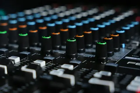 Close-up of a mixing board with colorful knobs, ready to shape sounds like a bitcrusher in FL Studio.