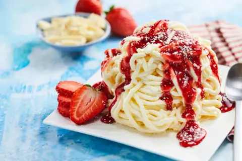 Spaghetti-Eis selber machen mit Kartoffelpresse: Cremiges Vanilleeis mit Erdbeersoße und frischen Erdbeeren. Ein süßer Genuss!