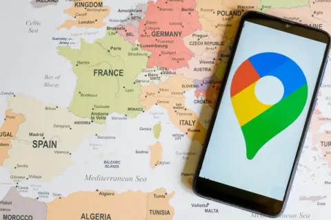 Mapa Europy z zaznaczonymi krajami i miastami, obok smartfon z ikoną Google Maps. Możliwa lokalizacja po numerze telefonu.