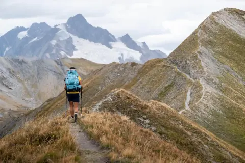 Wędrowiec na szlaku w **Alpach Austriackich**, podziwiający jedne z najpiękniejszych miejsc z lodowcem w tle.