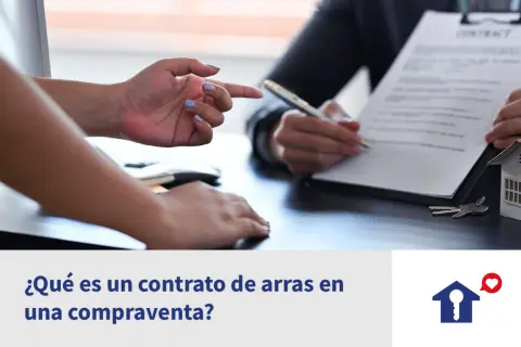 Manos firmando un contrato de arras confirmatorias, con llaves y maqueta de casa.