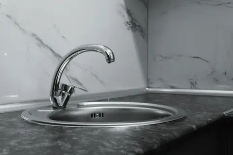 Nowa budowa baterii zlewozmywakowej stojącej. Bateria z chromowanym wykończeniem i okrągłym odpływem w zlewie.