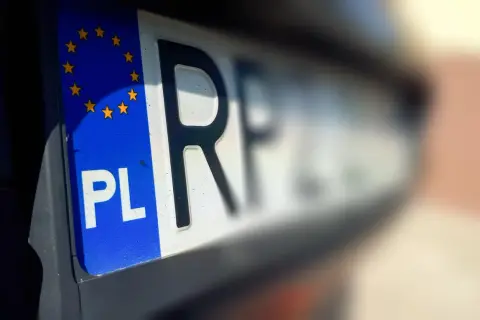 Zbliżenie na polską tablicę rejestracyjną z symbolem Unii Europejskiej. Litery "PL" i fragment numeru wskazują na rkl rejestracja.