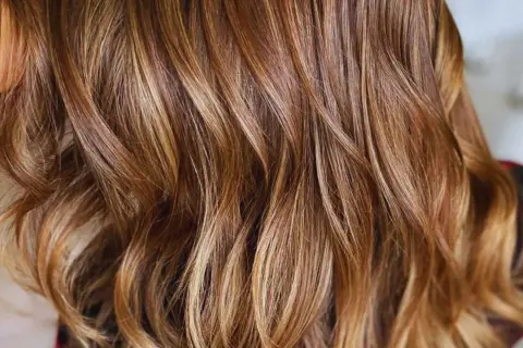 Cabello castaño con mechas rubias naturales que le dan un brillo y dimensión espectaculares.