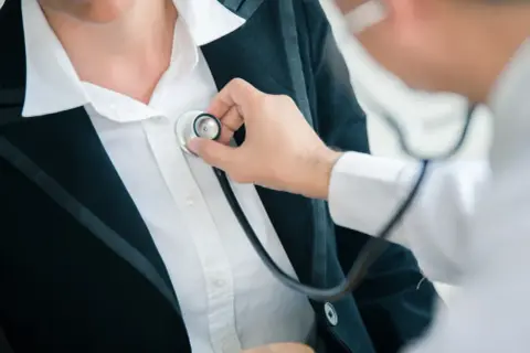 Lekarz osłuchuje pacjentkę stetoskopem podczas badań kontrolnych po L4.
