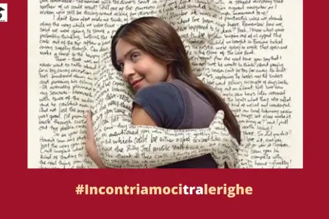 Un abbraccio avvolge una donna, il tessuto è ricoperto di testo. "Amici miei testo" è un invito a connettersi tra le righe.