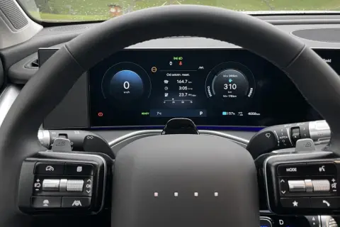 Wnętrze samochodu elektrycznego marki Hyundai. Na ekranie widoczny zasięg 310 km, zużycie energii i inne dane.