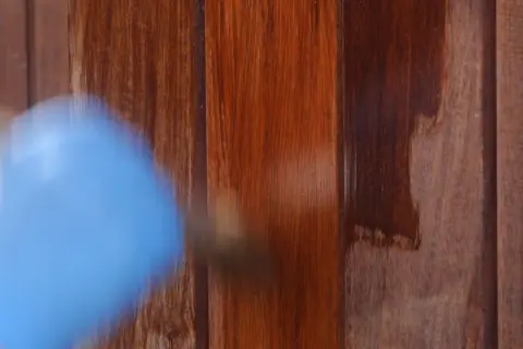 Aplicando barniz a madera impermeable para protegerla.