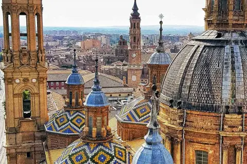 Las cúpulas y torres de las catedrales de Zaragoza, con sus coloridos tejados, se alzan sobre la ciudad.