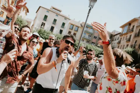 Un cantante con micrófono anima a la multitud en un festival. Gente con pulseras de acceso, un verdadero amante festival.