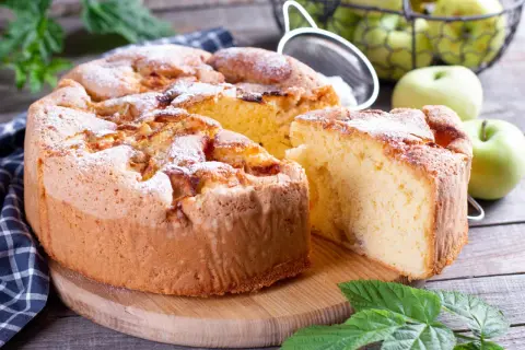 Saftiger Apfelkuchen, bestäubt mit Puderzucker. Ein Genuss für alle, die Kuchen ohne Zucker lieben.