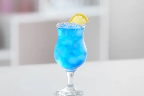 Erfrischender Blue Lagoon Cocktail mit Eis und Zitronenscheibe. Perfekt für dein Blue Lagoon Cocktail Rezept.