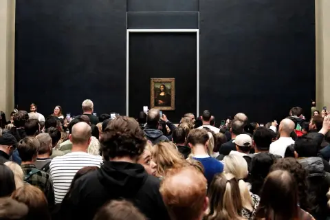 Multitud admira la Mona Lisa en el Louvre.