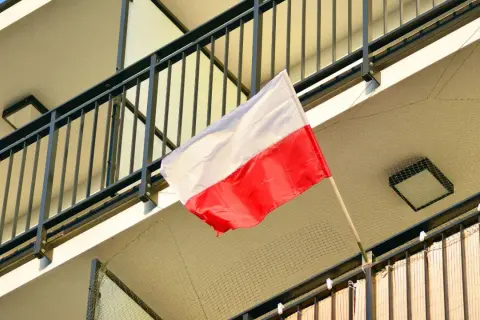 Polska flaga powiewa na balkonie. Biało-czerwone barwy symbolizują dumę i historię narodu.