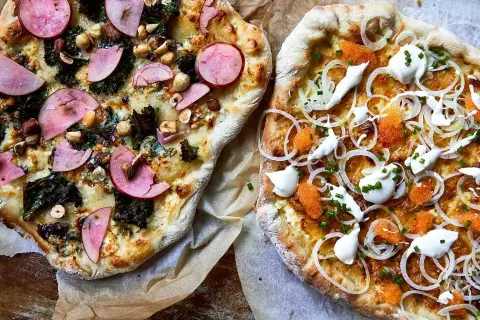 Två läckra pizzor, en med äpple och nötter, den andra en vit pizza med rom och gräddfil.
