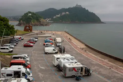 Aparcamiento de **San Sebastián en autocaravana**, con vistas al mar y a la montaña.
