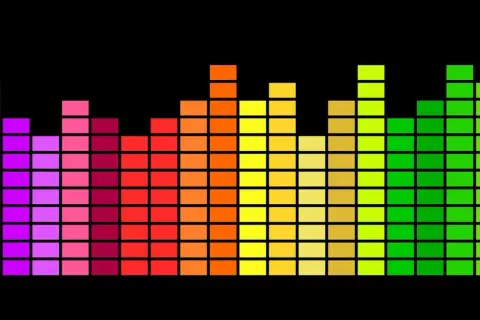 Kolorowy korektor dźwięku equalizer na czarnym tle, przypominający cyfrowy wykres muzyczny.
