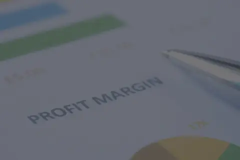Długopis na dokumencie z wykresem i tekstem "PROFIT MARGIN". Analiza danych, jak obliczyć marżę, by zwiększyć zyski.
