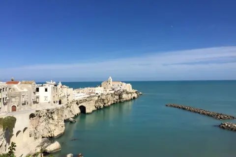 La piana della battaglia di Vieste, con le sue case bianche aggrappate alla roccia, si affaccia sul mare azzurro.