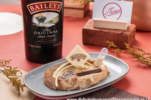 Torrijas de Baileys, un postre cremoso con un toque de licor irlandés, decorado con chocolate y una pipeta de salsa.