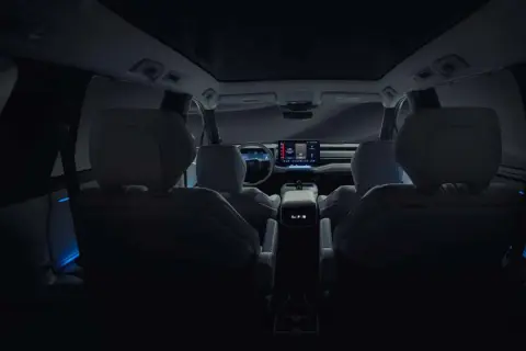 Wnętrze nowego Toyota Highlander nocą, z niebieskim nastrojowym oświetleniem i dużym ekranem multimedialnym.