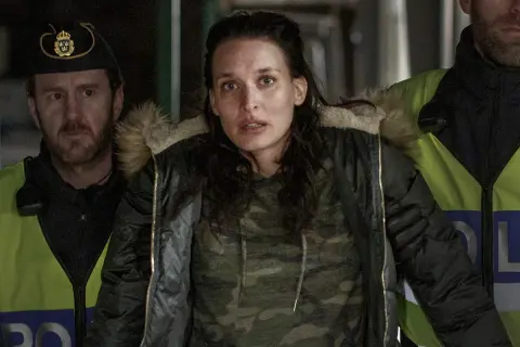En kvinna omgiven av poliser i en dramatisk scen från en norsk serie på SVT.