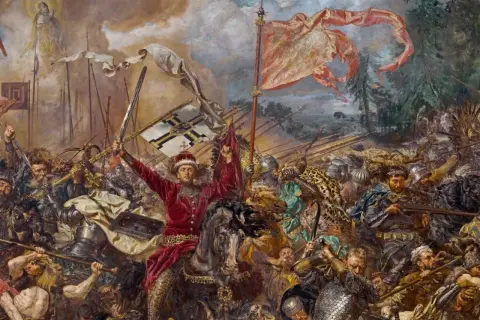 Jan Matejko ukazuje dynamiczną bitwę pod Grunwaldem. W centrum rycerz w czerwieni unosi miecz i chorągiew.