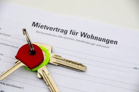 Schlüssel auf einem Mietvertrag. Der Vertrag ist für Wohnungen in Hamburg, und die Schlüssel symbolisieren den Einzug in ein neues Zuhause, vielleicht nach Prüfung des Betriebskostenspiegels Hamburg.
