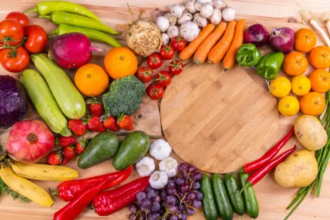 En färgsprakande samling frukter och grönsaker, som paprika, tomater, apelsiner och jordgubbar, som kan hjälpa mot c vitamin brist.