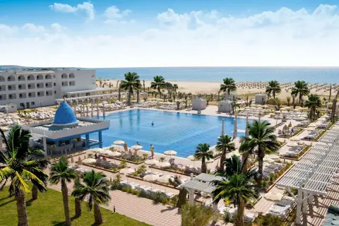 Luksusowy hotel Occidental Marco Polo nad morzem, z basenem, palmami i plażą.