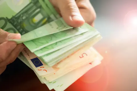Hände zählen Euro-Scheine. Die Frage, wie oft kann man 10.000 Euro einzahlen ohne Nachweis, bleibt offen.