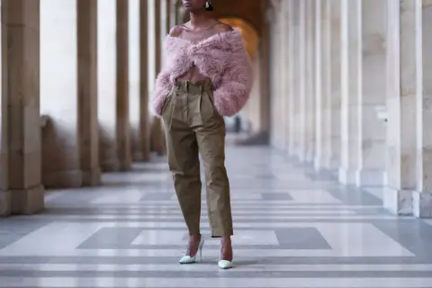 Eleganckie spodnie z wysokim stanem w stylizacji z puchatym bolerkiem i szpilkami.