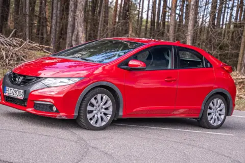 Czerwony Honda Civic UFO na leśnej drodze.