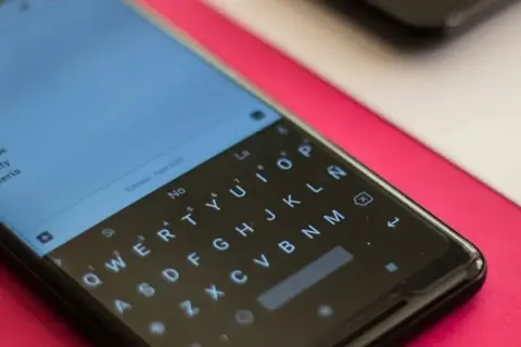 Pantalla de un smartphone con teclado QWERTY. Se busca cómo quitar vibración teclado para una experiencia más silenciosa.