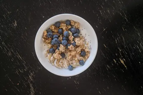 Un bol de skyr avec des myrtilles, des rondelles de banane et du granola. On peut chauffer le skyr pour un petit-déjeuner réconfortant.