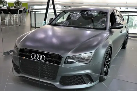 Matowy, szary Audi RS8 z czarnymi felgami i detalami, prezentowany w salonie.