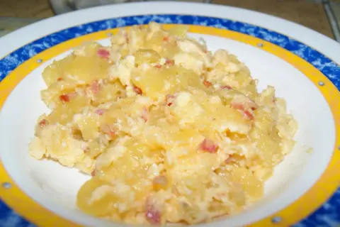 Patatas revueltas con huevo y trocitos de bacon, un plato casero delicioso y reconfortante.