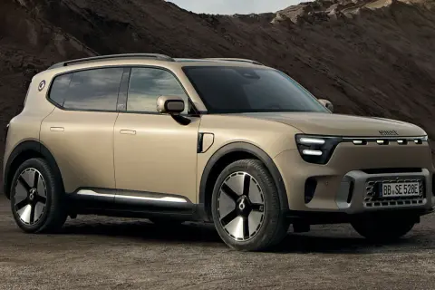 En smart 5-dörrars SUV i sandfärgad metallic står på en grusväg. Bilen har en modern design med LED-lampor och unika fälgar.