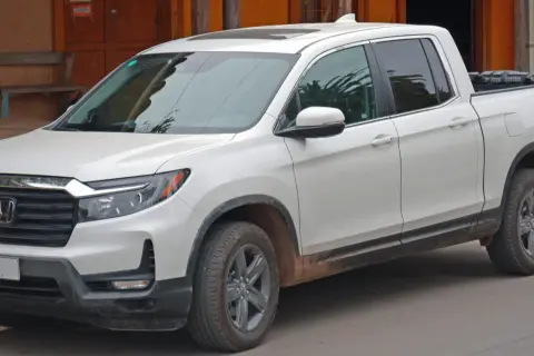 Biały Honda Ridgeline z błotem na progach, gotowy na przygodę.