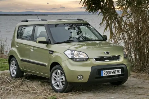Zielony Kia Soul na tle jeziora i trzcin. Wiele osób szuka kia soul opinie przed zakupem.