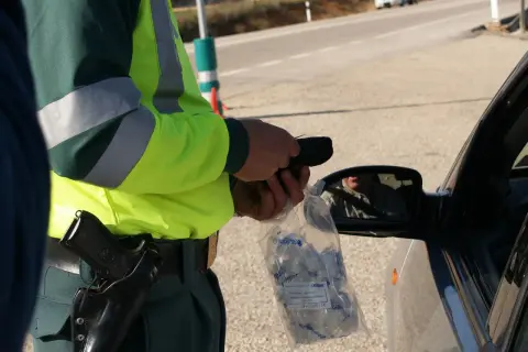 Policjant w kamizelce odblaskowej przeprowadza rutynową kontrolę trzeźwości. Podstawa prawna to bezpieczeństwo na drogach.