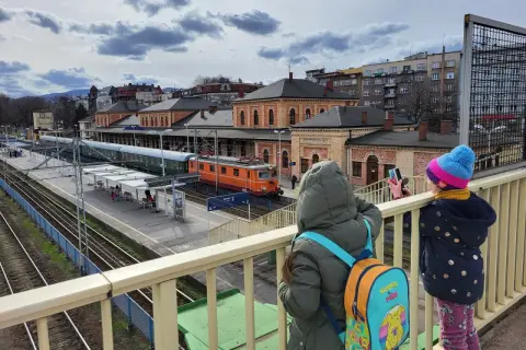 Dzieci na peronie obserwują pociągi, które pokazują, na co jeżdżą pociągi.