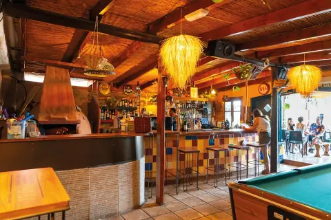 Bar acogedor con techo de paja, horno de leña y una mesa de billar. Ideal para disfrutar de un café moka en San José.