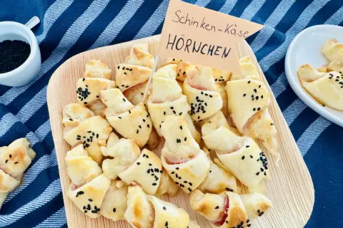 Schinken-Käse-Hörnchen, perfekt für ein karneval buffet kinder. Goldbraun gebacken, bestreut mit schwarzen Sesamkörnern.